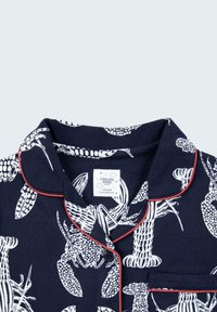 Navy pajama top featuring white lobster illustrations, red piping along the collar, and a tag with brand details. 100% cotton material.