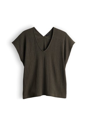 Blouse texturée à manches courtes vert olive foncé avec un décolleté en V et une coupe ample et boxy sur fond blanc.