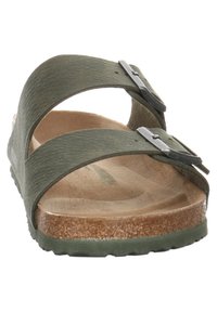 Green sandals featuring two textured straps with silver metal buckles, a natural cork footbed, and a lightweight rubber sole.