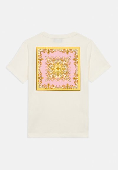 Μπεζ μπλουζάκι με διακοσμητικό μοτίβο σε ροζ και χρυσό σε σχήμα τετραγώνου στην πλάτη, με περίτεχνες σπείρες και σχήματα. Κοντά μανίκια.