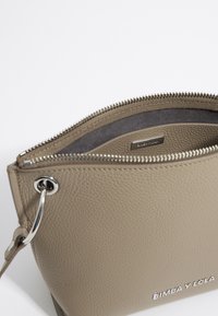 Pochette in pelle grigia con zip, dal finish testurizzato, dotata di una zip e hardware in argento, fodera interna discreta e un'etichetta con marchio all'interno.