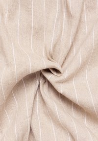 Tessuto beige con sottili strisce verticali bianche, superficie testurizzata, caduta morbida e una leggera lucentezza. Intrecciato in una forma sciolta.