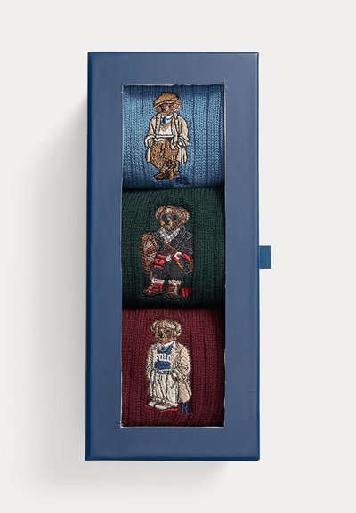 Conjunto de três pares de meias tricotadas em azul, verde e bordô, cada um apresentando desenhos únicos de ursos bordados com vários trajes.
