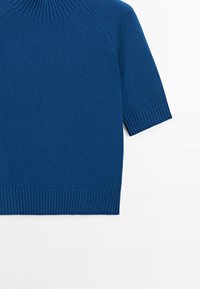 Modrý pletený svetr s krátkými rukávy, žebrovanými manžetami, lemem a výstřihem na bílém pozadí.