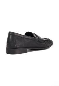 Black leather slip-on shoe with a low heel, featuring pleated detailing and silver studs across the vamp for added texture and design.