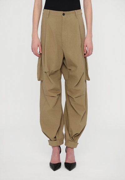 Pantalons larges en khaki avec poignets élastiques, poches avant et fermeture à bouton. Texture lisse, coupe décontractée, avec poches cargo sur les côtés.