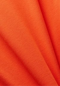 Tekstiilinäyte kirkkaan oranssissa kankaassa; sileä pinta, jossa hienovarainen jousto eikä näkyviä kuvioita tai korostuksia.