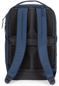 Zaino blu navy con schiena in tessuto nero imbottito e spallacci regolabili. Presenta cuciture rinforzate e un compartimento con cerniera.