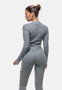 Grijs geribd shirt met lange mouwen en bijpassende broek. Strak ontwerp met een gestructureerde stof, met een cropped snit en een naadloze tailleband.