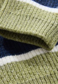 Õrna triibuga oliivirohelise soonikuga kudumkangas, tumesiniste ja valgete triipudega. Pehme tekstuur õrnalt uduselt viimistletud, nähtavad kattuvad kihid.