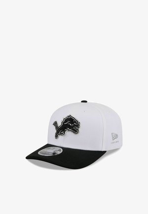 White and black baseball cap with a black lion logo on the front and New Era brand mark on the side.