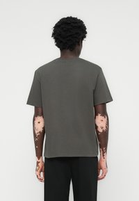 Dunkelgraues Kurzarm-T-Shirt aus weichem Stoff, mit einem Rundhalsausschnitt und lockerer Passform, das eine glatte Textur aufweist und keine sichtbaren Muster hat.