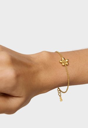 Bracciale in oro con design floreale caratterizzato da petali arrotondati, fissato con un piccolo gancio regolabile e un'estensione della catena.