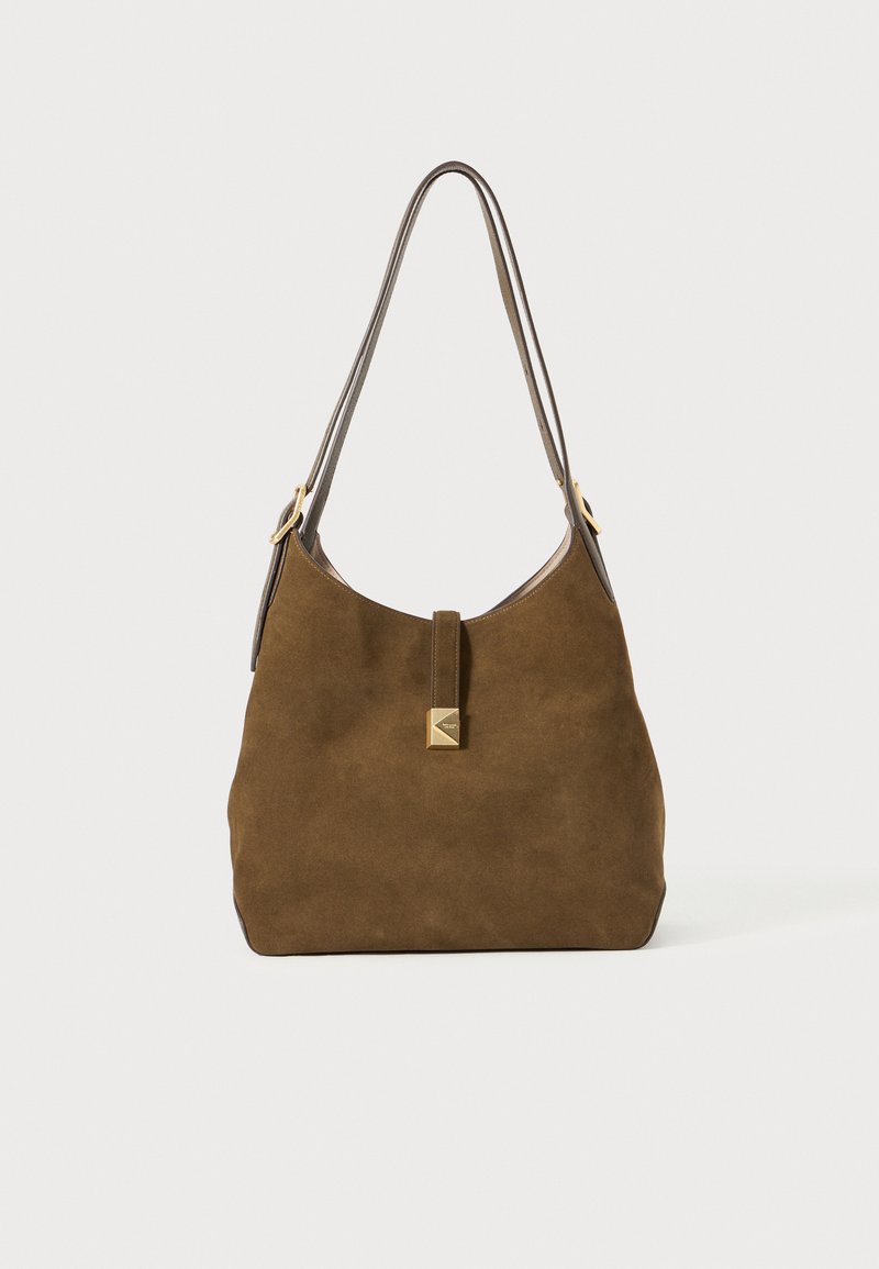 Brown suede bag with a rounded shape, thin shoulder strap, gold-tone hardware, and a front tab detail. Soft texture with minimal accents.