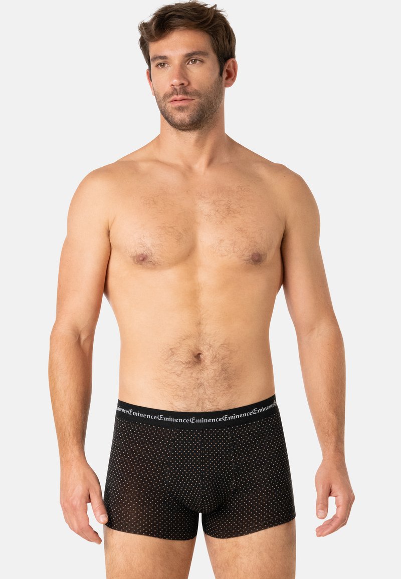 Caleçons-boxers noirs avec un motif à pois, taille élastique portant l'étiquette "Eminence", tissu doux et forme ajustée.