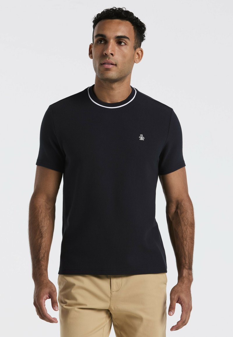 Navy gebreide t-shirt met korte mouwen, een ronde halslijn en witte afwerking. Bevat een klein logo op de linkerbovenborst.