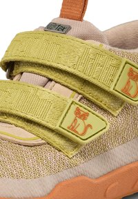 Helle gelbe Sneaker mit zwei Klettverschlüssen, die ein Katzenmotiv aufweisen. Strukturiertes Material, pinke Akzente und eine orangefarbene Zuglasche an der Ferse.