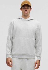 Grå hoodie med kængurulomme, snoretræk i hætten og ribbede manchetter. Blød tekstur, afslappet pasform, kombineret med matchende bukser.