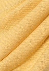 Gelber Strickstoff mit einer glatten Textur, der eine gleichmäßige, enge Webart und subtile Farbvariationen aufweist. Weich und gut fallend.