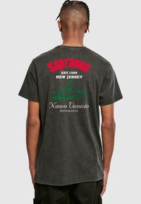 Černé bavlněné tričko s logem "The Sopranos" v červené barvě, textem "EST. 1999" a "NEW JERSEY", se grafikou restaurace Nuovo Vesuvio níže.