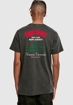 Sort bomulds T-shirt med "The Sopranos" logo i rød, teksten "EST. 1999" og "NEW JERSEY", samt en grafik af Nuovo Vesuvio restaurant nedenfor.