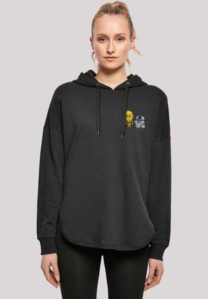 Sweat-shirt à capuche noir avec une coupe ample, arborant des graphismes de robots jaunes et bleus sur la poitrine, un cordon de serrage et des poignets côtelés.