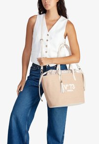 Borsa a tracolla intrecciata beige con dettagli bianchi, manici superiori, tracolla removibile e testo ricamato "N°73 VENEZIA." Texture liscia.