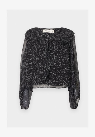 Μαύρο διάφανο μπλουζάκι με άσπρες πουά, μακριά φουσκωτά μανίκια, βολάν στον γιακά και κορδόνι στο ντεκολτέ, τοποθετημένο επίπεδα σε λευκό φόντο.