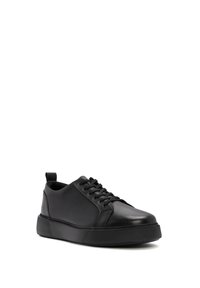 Black leather sneaker with round toe, lace-up front, and durable rubber sole. Features a side stitching detail and pull tab at heel.