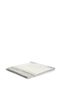 Plaid en laine dans les tons blanc et gris, avec un motif répétitif, des bords frangés et une finition douce et texturée.