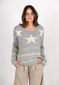 Grauer Strickpullover mit hellbeigen Sternmustern, strukturiertem Stoff und goldenen Akzenten, ergänzt durch einen lässigen Schnitt und V-Ausschnitt.