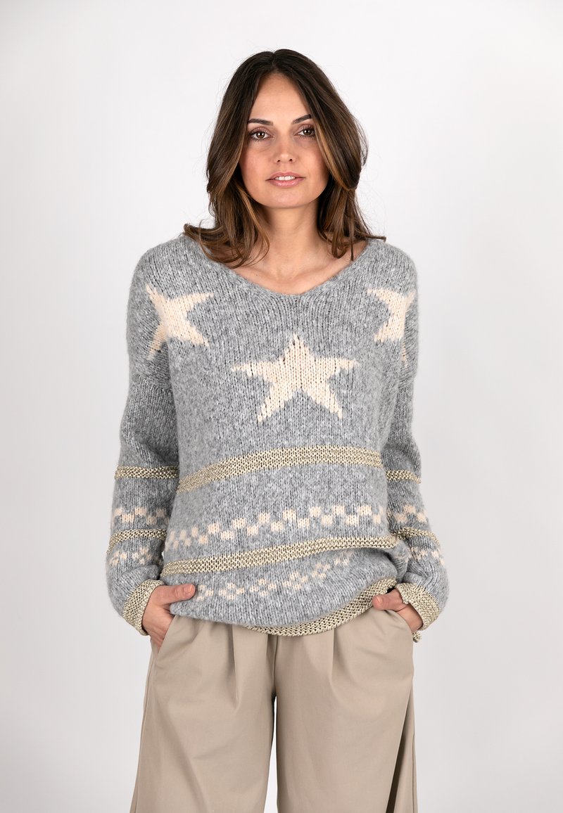 Grauer Strickpullover mit hellbeigen Sternmustern, strukturiertem Stoff und goldenen Akzenten, ergänzt durch einen lässigen Schnitt und V-Ausschnitt.