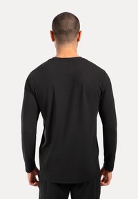 Czarny t-shirt z długim rękawem, wykonany z miękkiego materiału, z okrągłym dekoltem; ma prosty krój i minimalistyczny design bez widocznych logo.