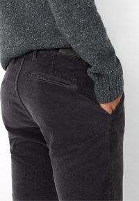 Dunkelgraue Cordhosen mit texturierter Oberfläche, slim fit, seitlichen Taschen und einer Gesäßtasche mit Logo-Tag.