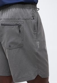 Γκρι σορτς με ελαστική μέση και δύο τσεπάκια με φερμουάρ, ένα στο πλάι και ένα πίσω, με μικρό λογότυπο "Roark".