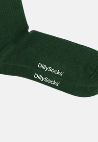 Calcetines de canalé verde oscuro con la marca "DillySocks" en blanco cerca de la parte superior. Cuentan con una textura suave y un diseño de longitud media en la pantorrilla.