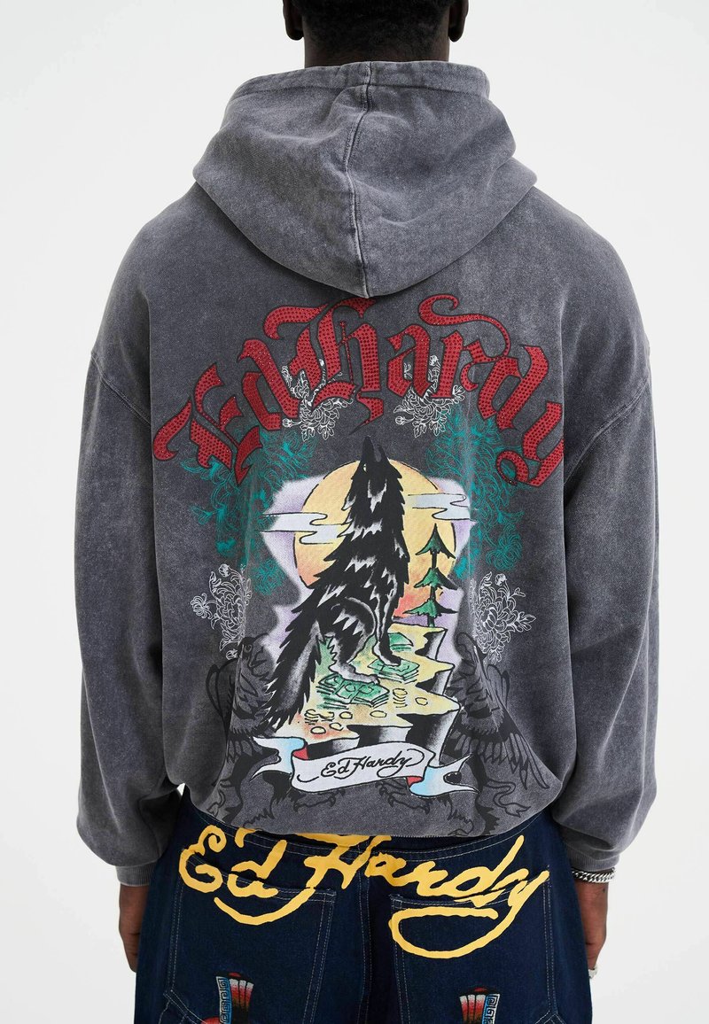 Grijze hoodie met kleurrijke wolf- en natuurgraphics op de achterkant, met "Ed Hardy" prominent weergegeven in rood en goud.