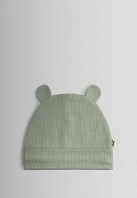 Žebrovaná zelená čiapka s zaoblenými uškami a zavinutým lemom. Na boku má malú tkanú štítok. Mäkký bavlnený materiál.