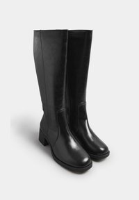 Svarta läderknähöga stövlar med blockklack, slät textur och subtila sidostickningar. Designade för funktionalitet och komfort.