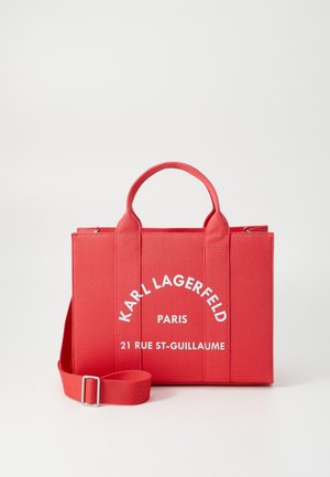 Czerwona prostokątna torba na ramię z dwoma uchwytami i regulowanym paskiem, z nadrukiem "Karl Lagerfeld Paris 21 Rue St-Guillaume" w białym kolorze.