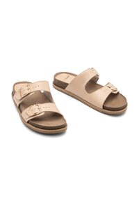 Beżowe klapki na slide z dwiema regulowanymi paskami, złotymi klamrami i miękką brązową wkładką. Podeszwa jest lekko teksturowana dla lepszej przyczepności.