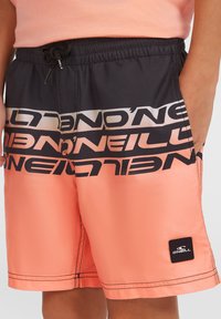 Shorts da nuoto con una combinazione di colori nero e corallo, caratterizzati da un grande marchio stampato, cintura elasticizzata e tasche laterali.