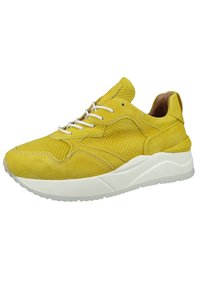 Żółte zamszowe sneakersy z białymi sznurowadłami i teksturowanym wierzchem. Posiadają masywną białą podeszwę oraz perforowane detale po bokach.