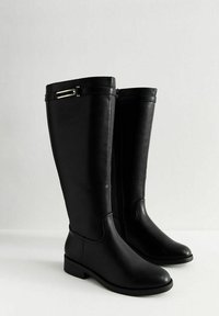 Botas de cuero negras hasta la rodilla con un acabado suave, cremallera lateral y un pequeño detalle metálico en la parte superior, con un tacón bajo.