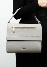 Grijze leren handtas met een bovenflap, een voorklep met rits en gouden hardware. Voorzien van een schouderband en een getextureerde afwerking.