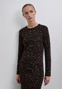 Vestido de punto con mangas largas, con base en marrón oscuro y un estampado de leopardo en tonos negro, crema y verde oscuro.