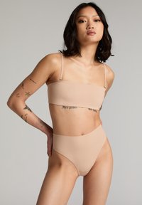 Nude bikini set met een strapless bandeau-top en high-waisted onderstuk. Soepele stof met een matte afwerking en minimale stiksels.