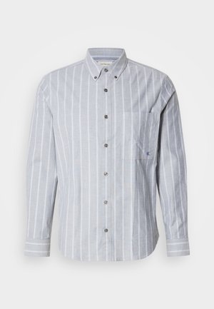 Light blue striped long-sleeve shirt with button-down collar, front pocket, and textured fabric. Features contrasting white vertical stripes.