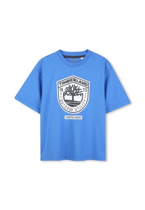 T-shirt en coton bleu avec un col rond, des manches courtes, et un grand logo Timberland en noir et blanc représentant un arbre et du texte.