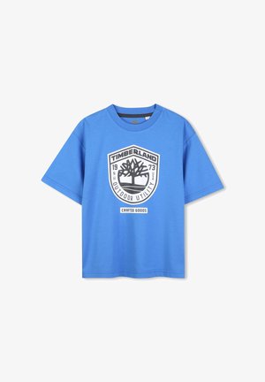 Maglietta di cotone blu con collo rotondo, maniche corte e un grande logo Timberland in bianco e nero che presenta un albero e del testo.